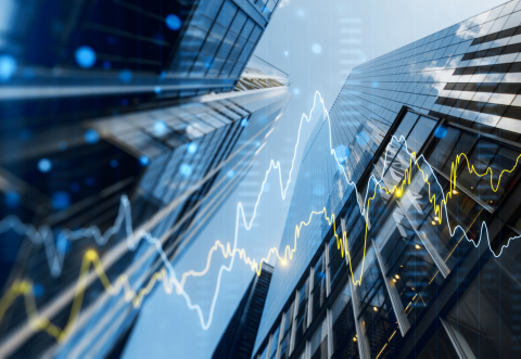 A double exposure image of skyscrapers with overlay of financial graphs, set against a blurred background, illustrating the concept of business growth